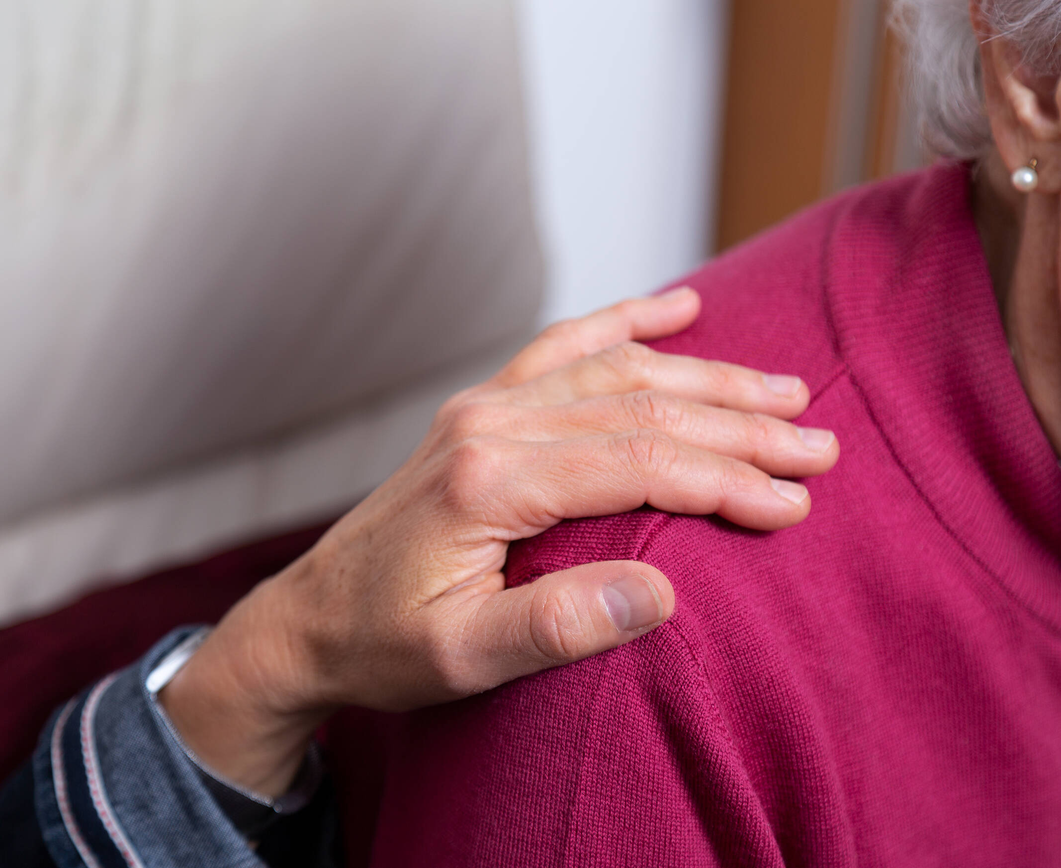 Ein Hand auf der Schulter einer älteren Person